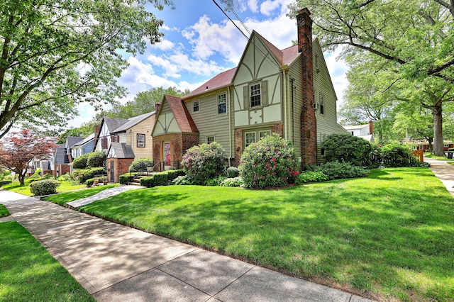 166 Roydon Rd, New Haven, CT 06511 - tudor-style house with a chimney, brick siding, a front lawn, and a residential view