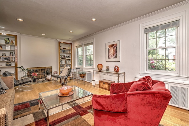166 Roydon Rd, New Haven, CT 06511 - living room with radiator, crown molding, a fireplace, built in features, and wood finished floors