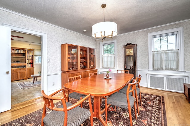 166 Roydon Rd, New Haven, CT 06511 - dining room with radiator heating unit, light wood-style flooring, ornamental molding, wallpapered walls, and a chandelier