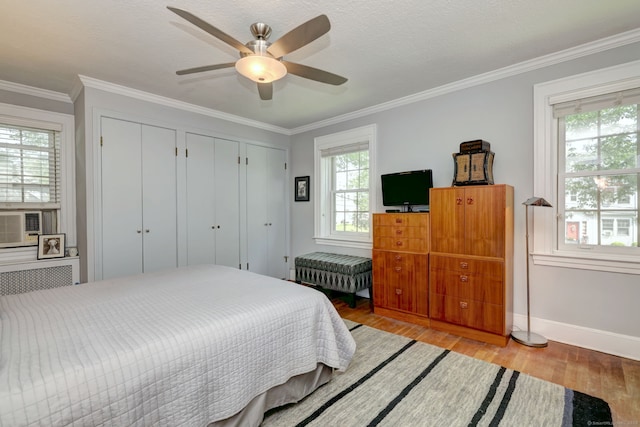 166 Roydon Rd, New Haven, CT 06511 - bedroom featuring light wood-style flooring, two closets, ornamental molding, and a ceiling fan