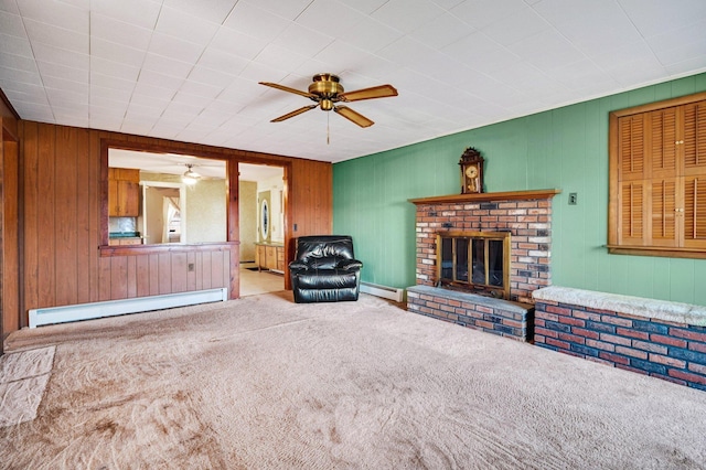 75 W Shore Rd, Ellington, CT 06029 - carpeted living room with a baseboard heating unit, ceiling fan, a fireplace, and wood walls