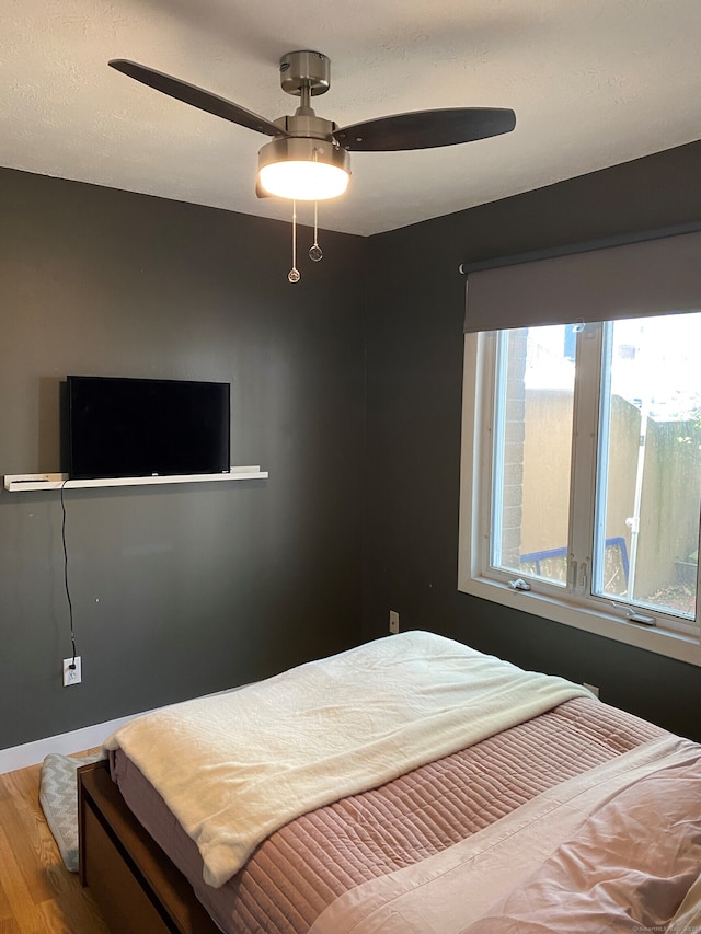 bedroom with wood finished floors, ceiling fan, and baseboards