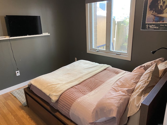 bedroom with wood finished floors and baseboards