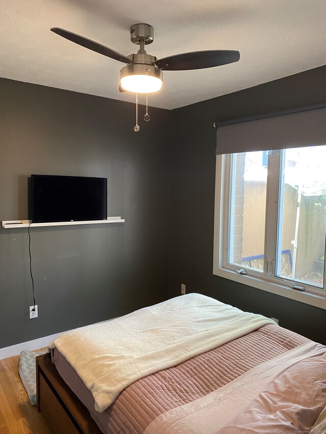 bedroom with wood finished floors, ceiling fan, and baseboards