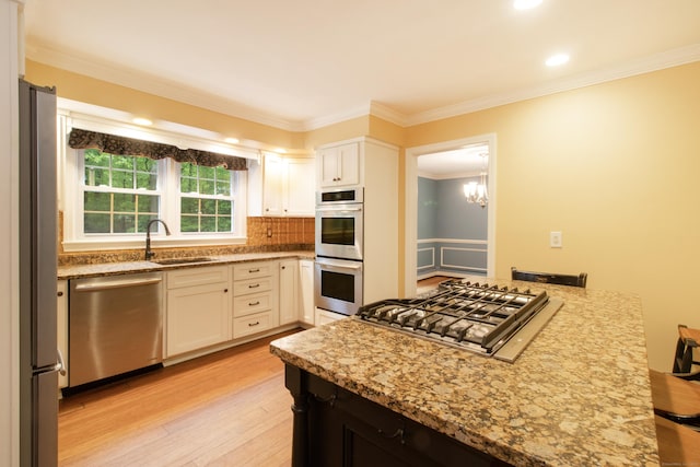 82 Whitethorn Dr, Guilford, CT 06437 - kitchen with appliances with stainless steel finishes, a sink, crown molding, light wood-style floors, and white cabinetry
