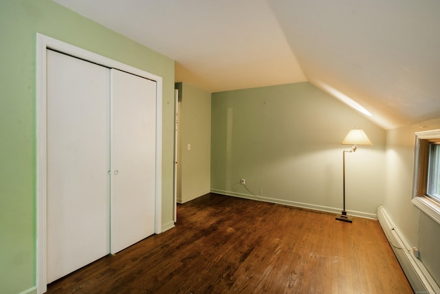 82 Whitethorn Dr, Guilford, CT 06437 - unfurnished bedroom with baseboard heating, vaulted ceiling, dark wood-type flooring, and a closet