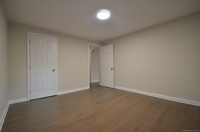14 Harvest Ln, Bristol, CT 06010 - unfurnished bedroom with dark wood-style flooring, baseboards, and arched walkways