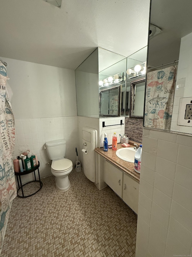 30 Woodland St Apt 5F, Hartford, CT 06105 - bathroom featuring tile walls, toilet, tile patterned floors, vanity, and wainscoting