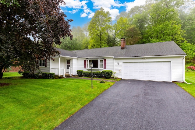 ranch-style home featuring asphalt driveway, a garage, a chimney, and a front lawn