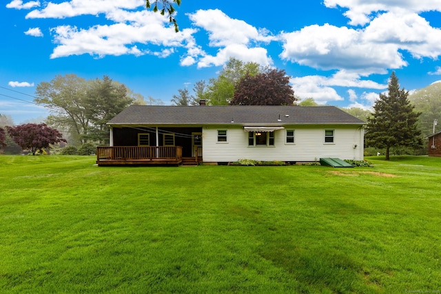 back of house with a wooden deck and a lawn