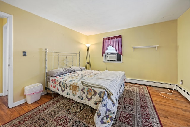 bedroom featuring wood finished floors, cooling unit, and baseboards