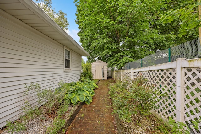 view of yard with a storage unit, fence, and an outdoor structure