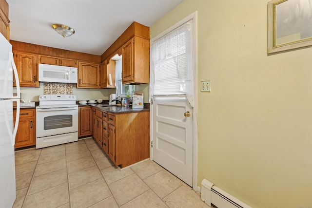kitchen featuring white appliances, brown cabinetry, a baseboard heating unit, a sink, and light tile patterned floors