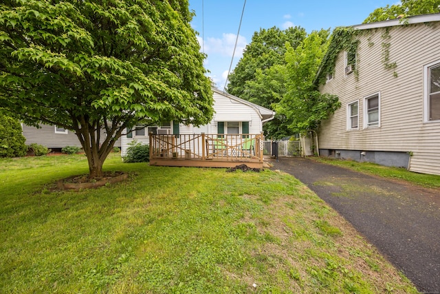 view of green lawn featuring a deck