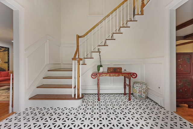 33 Carrington Dr, Stamford, CT 06831 - staircase featuring a decorative wall, tile patterned floors, and a wainscoted wall