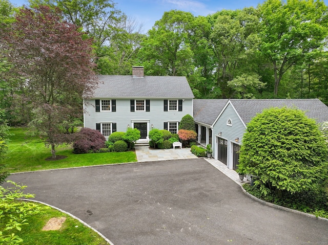 33 Carrington Dr, Stamford, CT 06831 - colonial house with asphalt driveway, a chimney, roof with shingles, and a garage