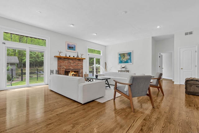 20A Bush Hill Dr, East Lyme, CT 06357 - living room featuring plenty of natural light, wood finished floors, a brick fireplace, and recessed lighting