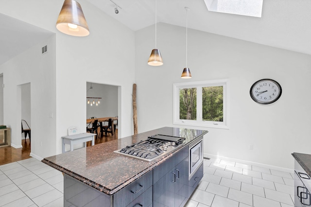 20A Bush Hill Dr, East Lyme, CT 06357 - kitchen with stainless steel appliances, high vaulted ceiling, light tile patterned floors, baseboards, and hanging light fixtures