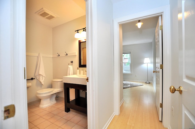 15 Highland St Apt 106, West Hartford, CT 06119 - bathroom with toilet, vanity, baseboards, and wood finished floors