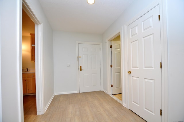 15 Highland St Apt 106, West Hartford, CT 06119 - hallway with light wood-style flooring, baseboards, and a sink