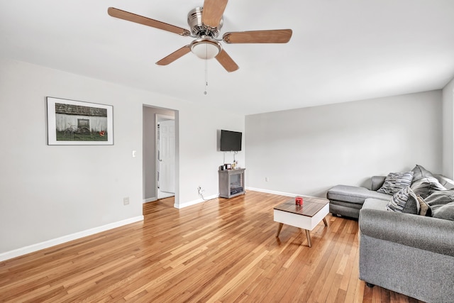 living room featuring a ceiling fan, light wood-style floors, and baseboards