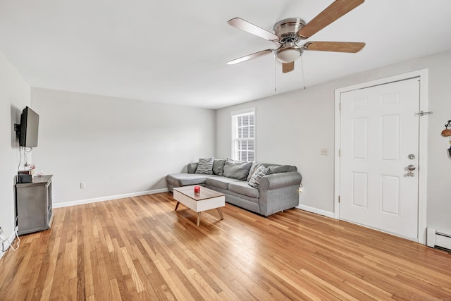 living area featuring ceiling fan, light wood-style flooring, and baseboards