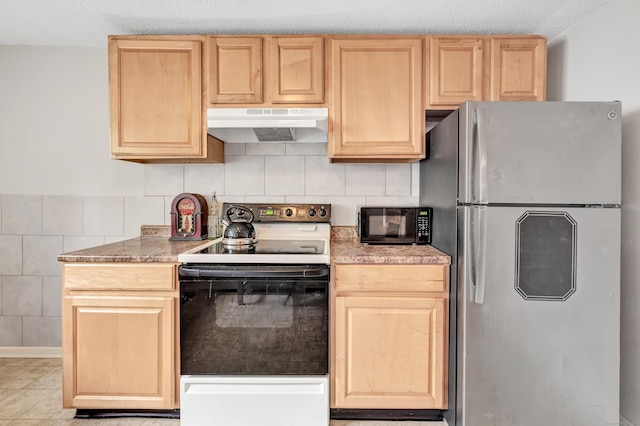 kitchen with freestanding refrigerator, under cabinet range hood, electric stove, and light brown cabinets