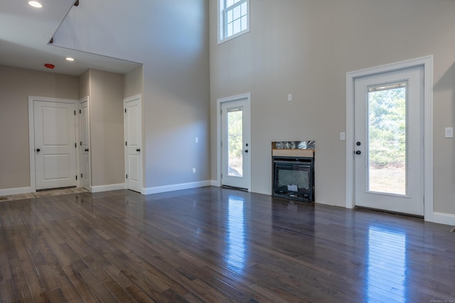 2 Stratton Farms Rd, Suffield, CT 06093 - unfurnished living room featuring dark wood-type flooring, a high ceiling, baseboards, a multi sided fireplace, and recessed lighting