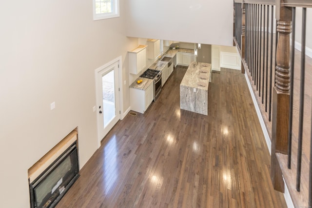2 Stratton Farms Rd, Suffield, CT 06093 - unfurnished living room with a towering ceiling, dark wood-style floors, and baseboards