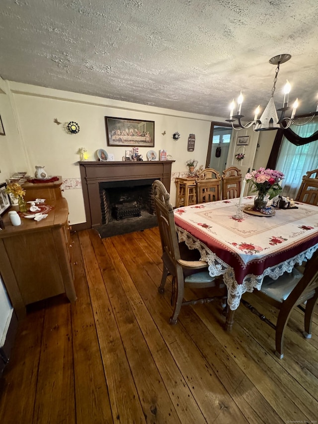 23 Old Mill Rd, Clinton, CT 06413 - dining space featuring a textured ceiling, a chandelier, hardwood / wood-style floors, and a fireplace
