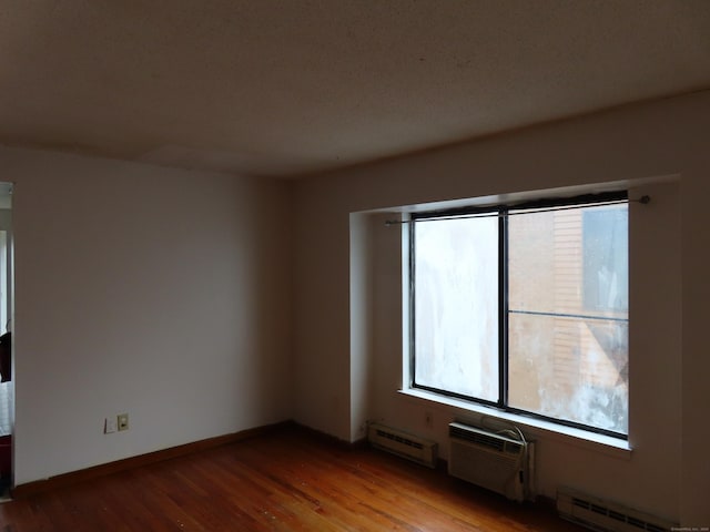 110 Bond St Unit 5B, Hartford, CT 06114 - spare room with baseboard heating, wood finished floors, a wall unit AC, and baseboards