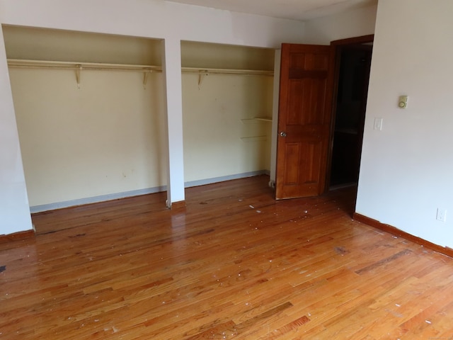110 Bond St Unit 5B, Hartford, CT 06114 - unfurnished bedroom with multiple closets, light wood-style flooring, and baseboards