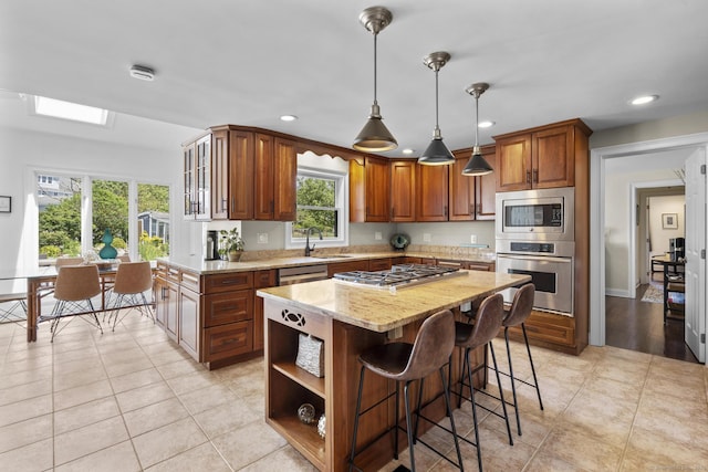 190 Bayview Blvd, Stratford, CT 06615 - kitchen with stainless steel appliances, a sink, light stone countertops, a breakfast bar area, and light tile patterned floors