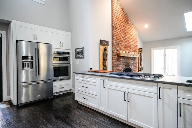 8 Bruce Ln, Avon, CT 06001 - kitchen with stainless steel appliances, dark wood-style flooring, high vaulted ceiling, and white cabinetry