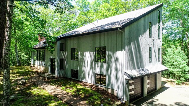 8 Bruce Ln, Avon, CT 06001 - view of property exterior featuring a garage, a chimney, a shingled roof, and driveway