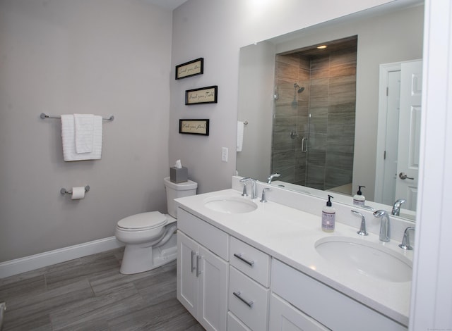 78 Copper Square Dr Unit 78, Bethel, CT 06801 - bathroom featuring a shower stall, double vanity, baseboards, toilet, and wood finished floors