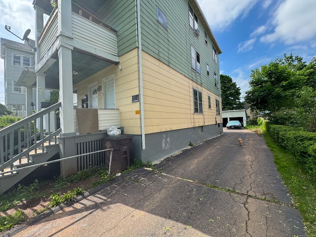 view of side of property with covered porch and a detached garage