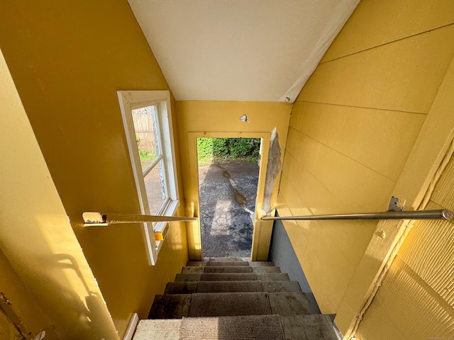 stairs with vaulted ceiling and carpet