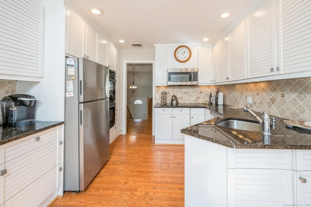 90 Akbar Rd, Stamford, CT 06902 - kitchen featuring stainless steel appliances, light wood-style flooring, a sink, white cabinetry, and tasteful backsplash