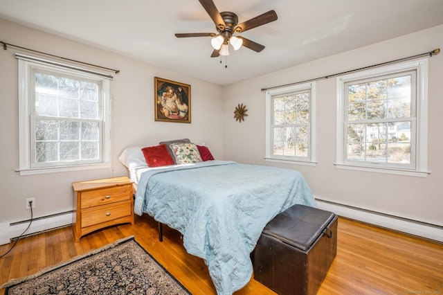 90 Akbar Rd, Stamford, CT 06902 - bedroom with wood finished floors, a baseboard heating unit, baseboard heating, and ceiling fan