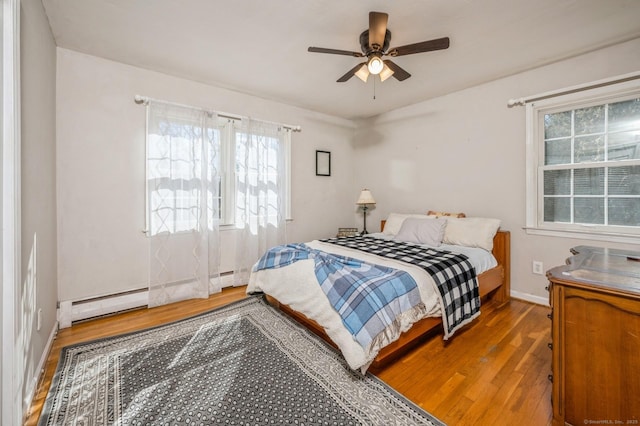 90 Akbar Rd, Stamford, CT 06902 - bedroom featuring wood finished floors, baseboards, multiple windows, and baseboard heating