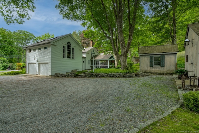 80 W Main St, Chester, CT 06412 - view of side of property featuring a garage, gravel driveway, and an outbuilding