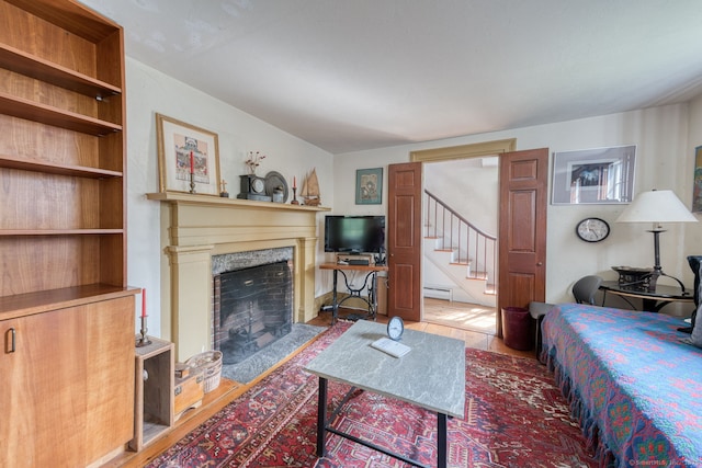 80 W Main St, Chester, CT 06412 - living area with wood finished floors, a baseboard radiator, stairway, and a fireplace with flush hearth