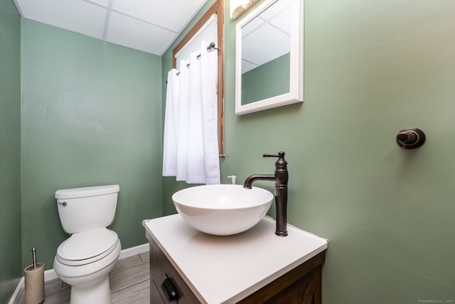 26 Davis Ave, Vernon, CT 06066 - bathroom with vanity, toilet, a paneled ceiling, baseboards, and wood finished floors