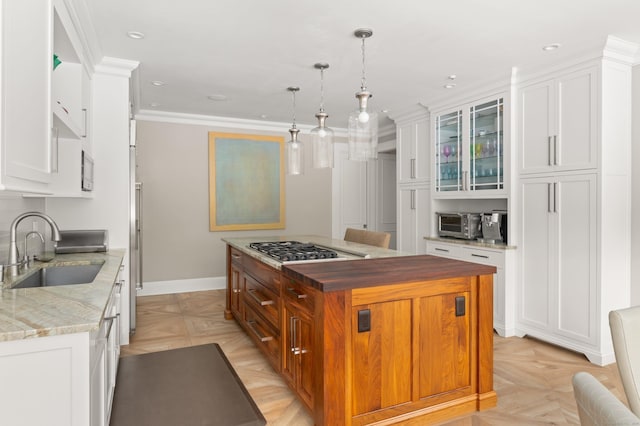 15 Arrowhead Way, Weston, CT 06883 - kitchen with a sink, stainless steel gas cooktop, white cabinetry, crown molding, and a center island