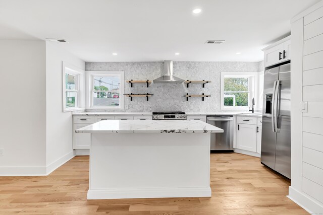 119 Melba St, Milford, CT 06460 - kitchen with stainless steel appliances, wall chimney range hood, a sink, a kitchen island, and decorative backsplash