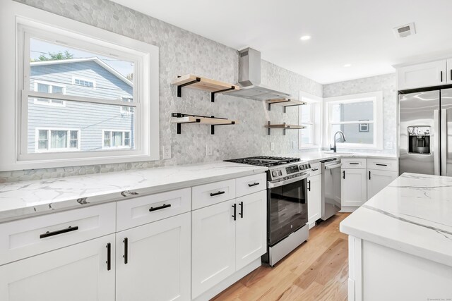 119 Melba St, Milford, CT 06460 - kitchen with stainless steel appliances, wall chimney exhaust hood, light wood-style floors, light stone countertops, and white cabinetry