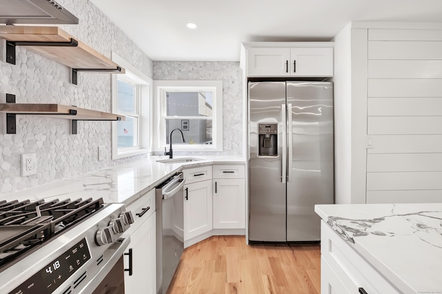 119 Melba St, Milford, CT 06460 - kitchen with stainless steel appliances, a sink, open shelves, light wood finished floors, and light stone counters