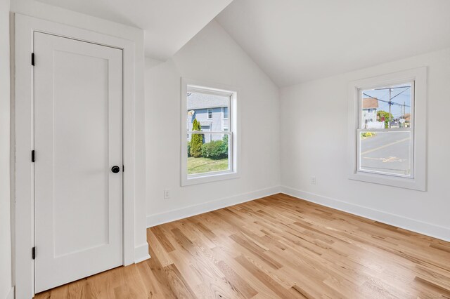 119 Melba St, Milford, CT 06460 - unfurnished bedroom with lofted ceiling, multiple windows, light wood-type flooring, and baseboards