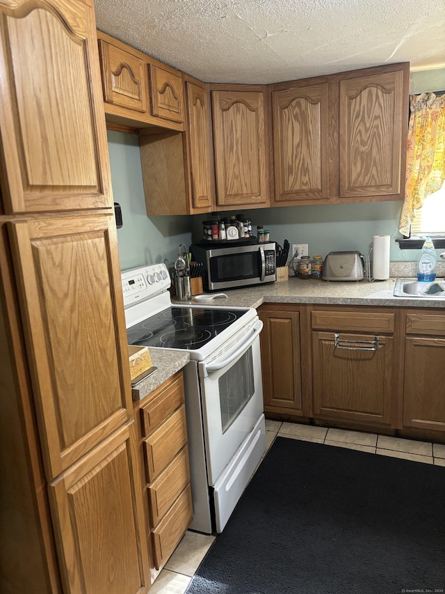 6 Peach St, Waterbury, CT 06708 - kitchen with white range with electric cooktop, stainless steel microwave, light tile patterned floors, light countertops, and a sink